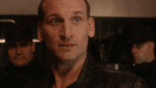 a close up of a man 's face with a black jacket on