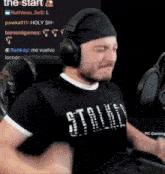 a man wearing headphones and a black shirt with the word stalk on it