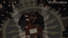 a group of people are gathered around a table with the hashtag #carnivalrow above them