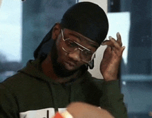 a man wearing glasses and a head scarf looks down
