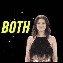 a woman in a black top is smiling in front of a sign that says good luck both