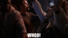 a man and woman are dancing in a dark room and the woman is saying whoo .