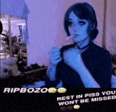 a girl is smoking a cigarette in a room and says rip bozo rest in piss you won t be missed