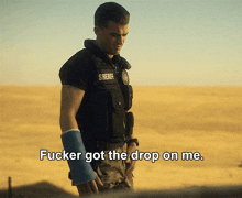 a man in a sheriff 's uniform is standing in the desert
