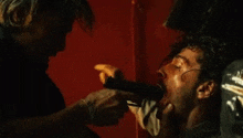 a man is cutting another man 's ear with a knife .