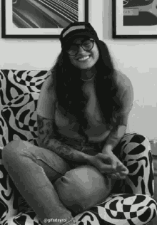 a black and white photo of a woman sitting on a chair