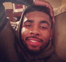 a man with a beard wearing a hoodie looks at the camera