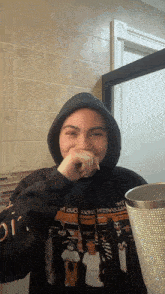 a woman wearing a black hoodie with a picture of a group of people on it