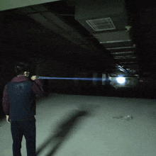 a man is holding a light in a dark room