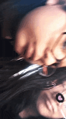 a blurry picture of a woman 's face with glasses