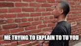 a man is standing in front of a brick wall with the caption `` me trying to explain to you '' .