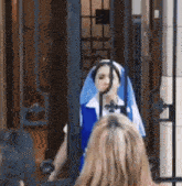 a woman in a nun costume stands in front of a fence