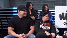 a boy wearing a hoodie that says rig sits next to a man and a woman