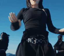 a woman in a black dress has a belt with holes in it