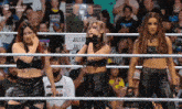 three women standing in a wrestling ring with a sign that says july 20