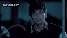 a man is holding a sickle in his hand and looking at the camera .