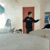 a man is dancing in a classroom with a woman sitting at a desk in the background .