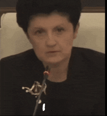 a woman sitting in front of a microphone with the word mhhhh on the bottom left