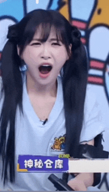 a girl with pigtails is making a funny face with her mouth wide open