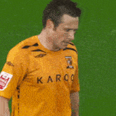 a man in a yellow aroo jersey covers his face