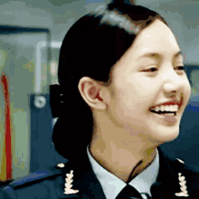 a woman in a military uniform is smiling and wearing a badge that says ' army ' on it