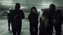a group of people are standing in a parking garage .