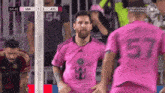 a soccer player in a pink shirt with the number 57 on it