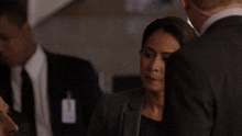 a woman in a suit has a name tag that says ' a. ' on it