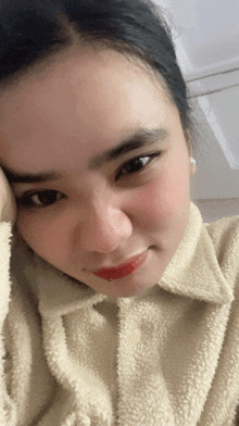 a close up of a woman 's face with her hand on her face
