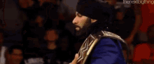 a man with a beard is wearing a wrestling championship belt .
