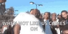 a group of people are standing next to each other with the words `` when not like us comes on '' written above them .