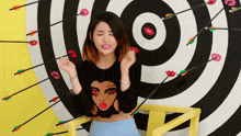 a woman is sitting in front of a target with arrows pointing to her face