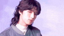 a young man with long hair and a mullet is wearing a bomber jacket and a white turtleneck .
