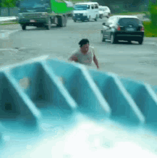 a man in a white shirt is running down a staircase in front of a busy street .