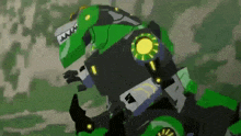 a green and black robot is standing in the woods .