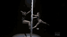 a man and a woman are dancing on a pole and the fox logo is visible