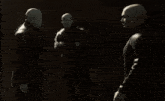 a group of bald men are standing next to each other in a dark room
