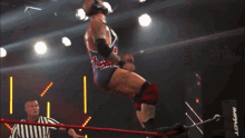 two men are wrestling in a ring with the number 16 on the wall in the background