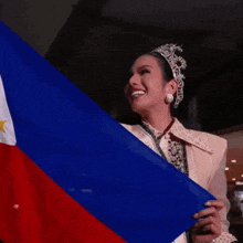 a woman wearing a crown is holding a flag