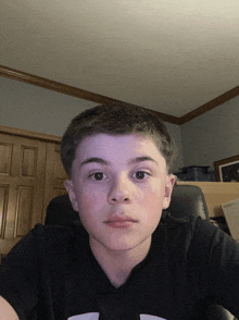 a young boy is taking a selfie in a bedroom