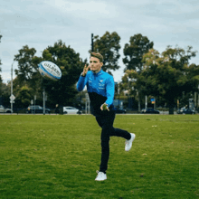 a man throws a gilbert rugby ball in the air