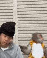 a man and a monkey are standing next to each other in front of a garage door .