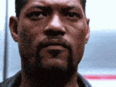 a man with a beard is looking at the camera with his eyes closed
