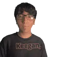 a man wearing glasses and a keegan shirt