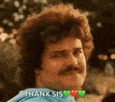 a man with curly hair and a mustache is making a funny face and saying thank you .