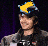 a man wearing a hat with the letter b on it is smiling