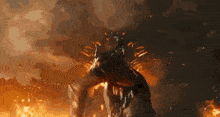 a monster is surrounded by flames and smoke in a dark room .