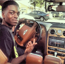 a young man sitting in a bentley car giving the middle finger