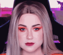 a close up of a woman 's face with red eyeshadow and red lips