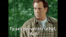 a man in a plaid shirt is talking in a foreign language while wearing a scarf around his neck .